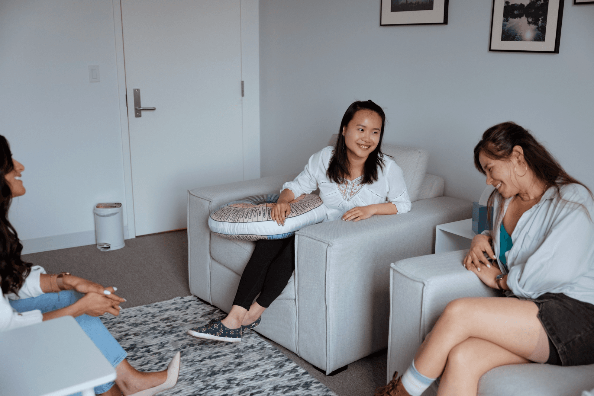 Women laughing around a couch at Grace Therapy and Wellness Center