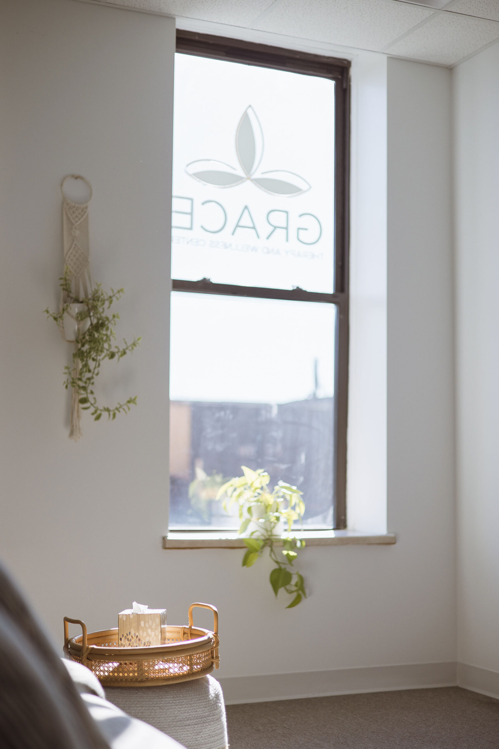 Grace Therapy and Wellness Center logo reflecting off window in office