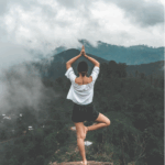 woman on mountain doing yoga - healing trauma with yoga gtwc
