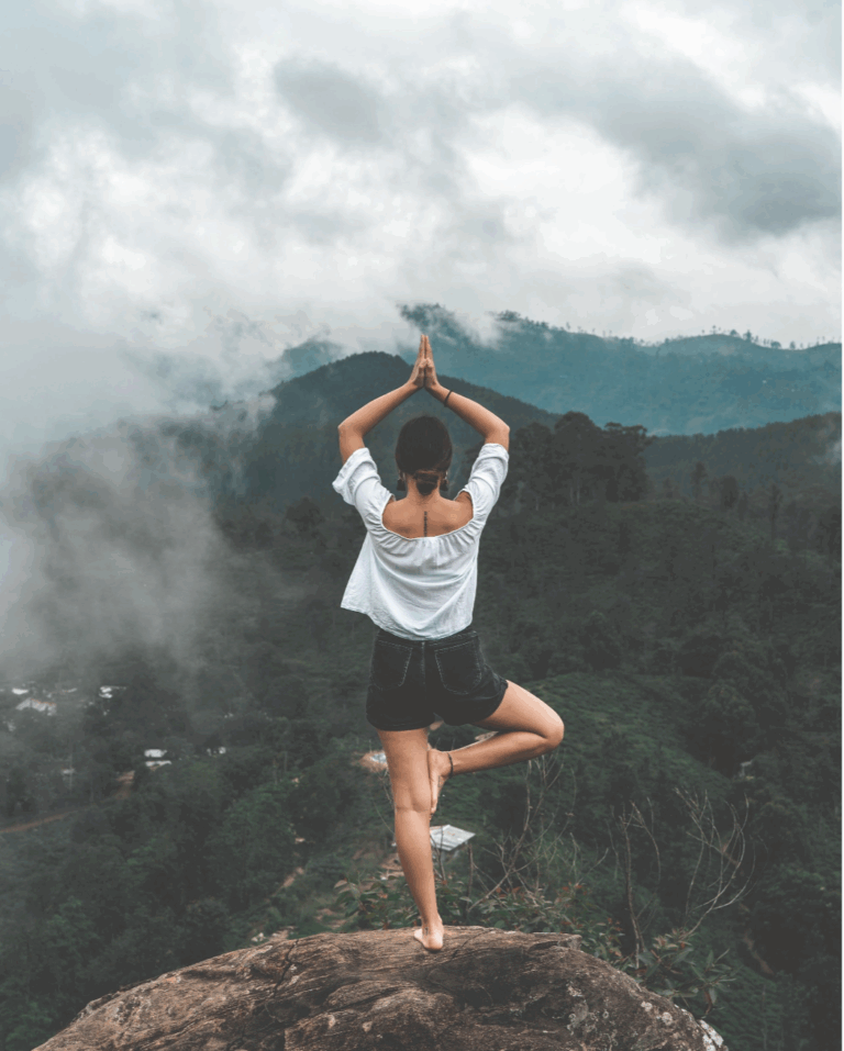 woman on mountain doing yoga - healing trauma with yoga gtwc