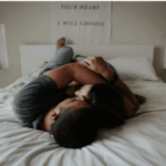 male and female couple laying in bed with "your heart I will choose" text poster in background - gtwc sex therapy article