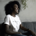black woman sitting on couch smiling - gtwc person centered therapy