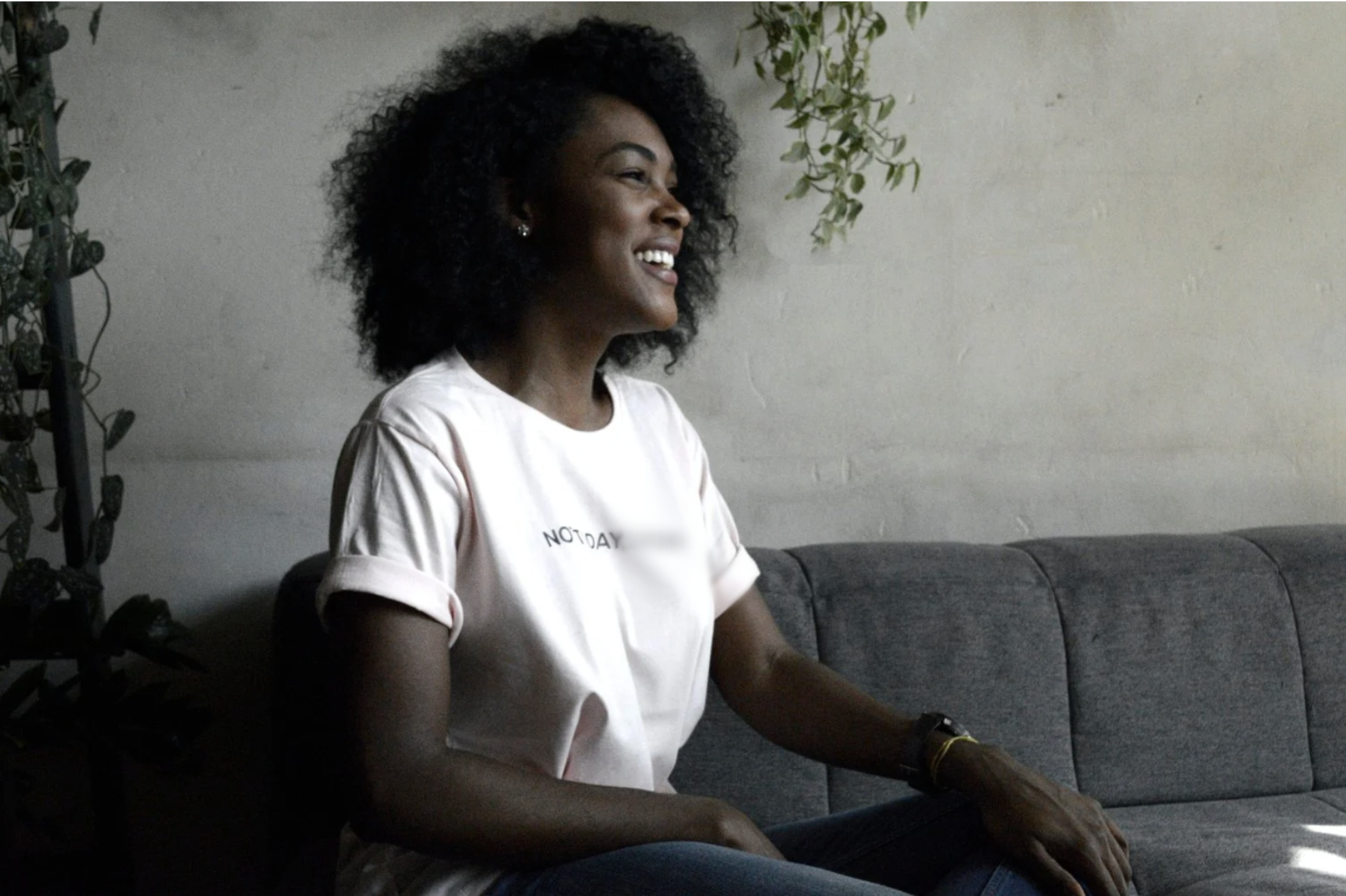 black woman sitting on couch smiling - gtwc person centered therapy